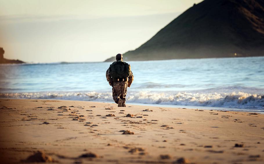 A soldier sprints on the beach during a tactical beach road march at Bellows Air Force Station, Waimanalo, Hawaii, March 27, 2018.