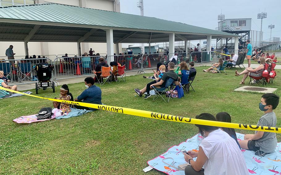 People and families practice social distancing during an outdoor church service at Yokosuka Naval Base, Japan, Sunday, May 31, 2020.