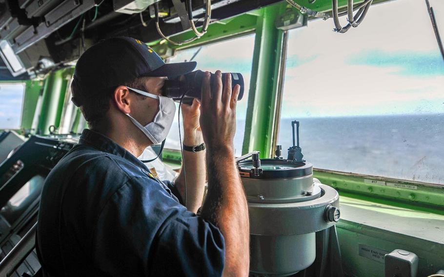 Ensign Ryan O'Neal searches for surface contacts from the pilot house as the guided-missile destroyer USS Russell sails through the Taiwan Strait, Thursday, June 4, 2020.