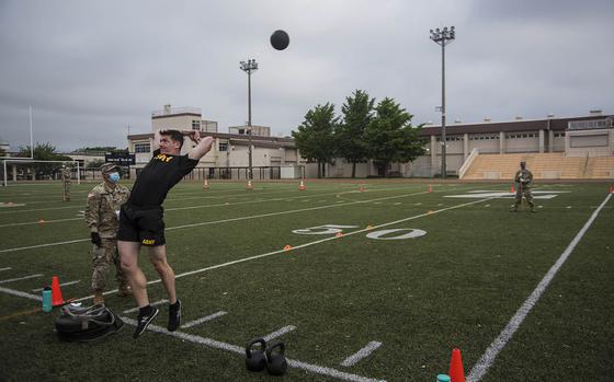 A soldier hurls a 10-pound medicine ball during a combat fitness test competition at Camp Zama, Japan, Monday, June 8, 2020.