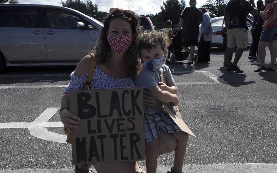 Air Force spouse Sienna Searle holds up a Black Lives Matter sign with son, Ronin, during a vigil at Kadena Air Base, Okinawa, Saturday, June 13, 2020.