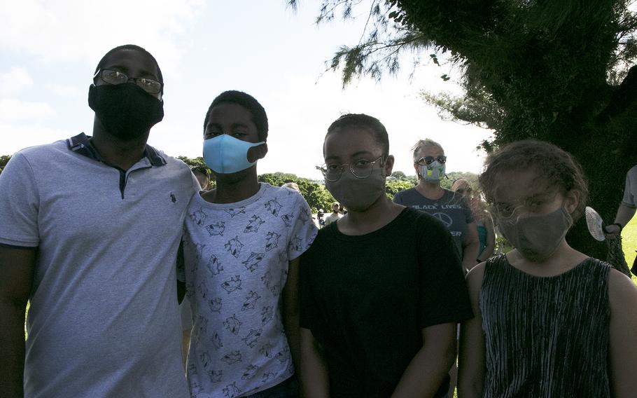 Air Force Tech Sgt. Louis Evan Knox and his children, left to right, Andreas, 12, Katalina , 12, and Jayla , 10, attend a vigil at Kadena Air Base, Okinawa, in memory of George Floyd, Saturday, June 13, 2020.