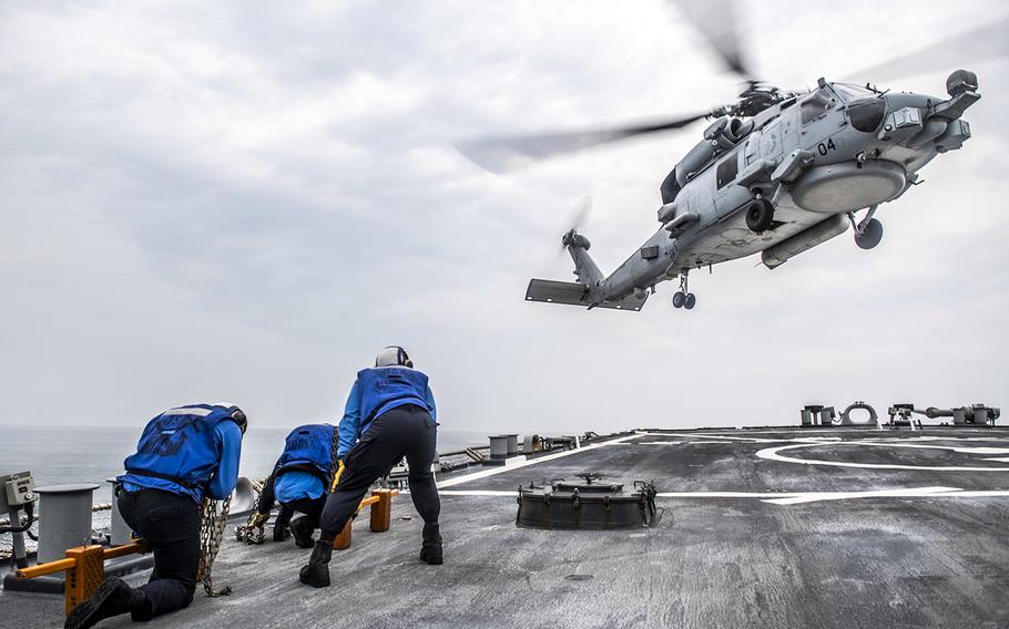 An MH-60R Sea Hawk lands aboard the guided-missile destroyer USS John S. McCain in the Philippine Sea, May 26, 2020.