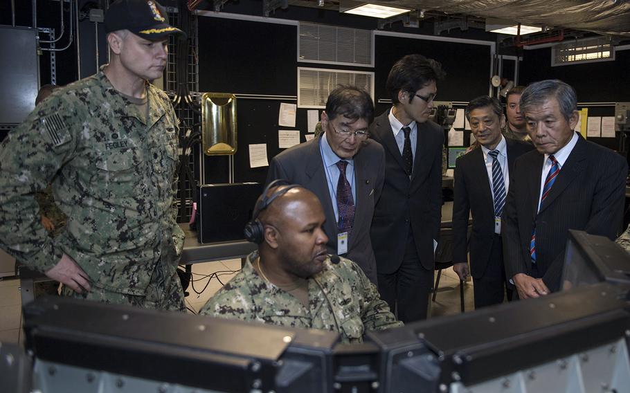 Navy Cmdr. Mark Fegley, left, of Aegis Ashore Missile Defense System Romania gives members of the Japanese Diet Council for Comprehensive Security a tour of the combat information center, Oct. 6, 2017.