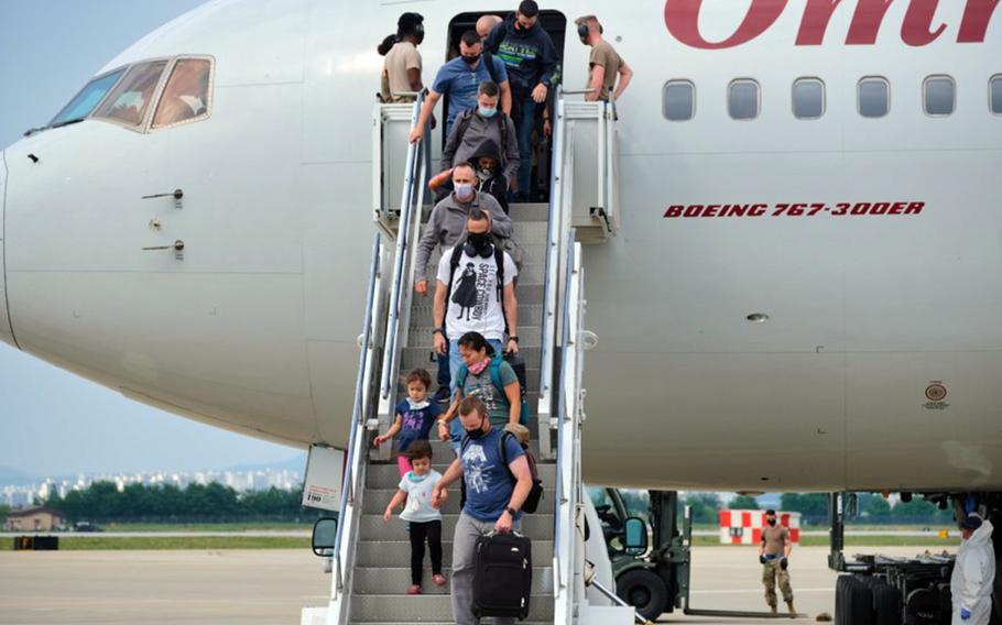 Passengers exit a Patriot Express flight at Osan Air Base, South Korea, June 10, 2020.
