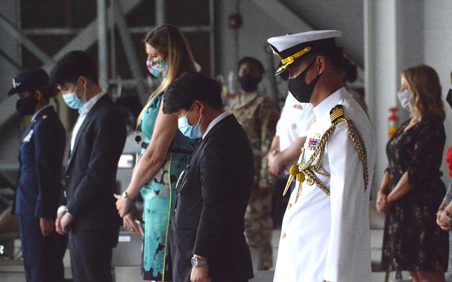 People bow their heads for a moment of silence during a repatriation ceremony for South Korean service members at Joint Base Pearl Harbor-Hickam, Hawaii, Tuesday, June 23, 2020.