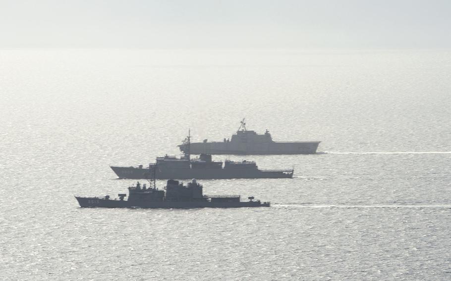 The Japan Maritime Self-Defense Force ships JS Kashima, bottom, and JS Shimayuki, center, sail alongside the littoral combat ship USS Gabrielle Giffords during an exercise in the South China Sea, Tuesday, June 23, 2020.