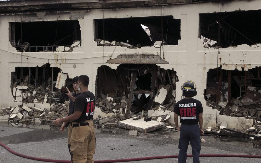 Firefighters survey damage at Kadena Air Base, Okinawa, Tuesday, June 23, 2020, the day after a blaze engulfed a hazardous materials building and released chlorine gas into the air.