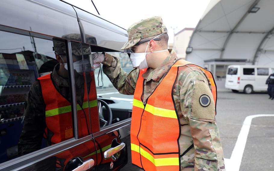 A soldier screens a driver for the coronavirus at Camp Zama, Japan, March 31, 2020.