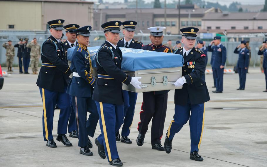 A United Nations Command honor guard carries the remains of six service members killed in the Korean War during a repatriation ceremony at Osan Air Base, South Korea, Friday, June 26, 2020.