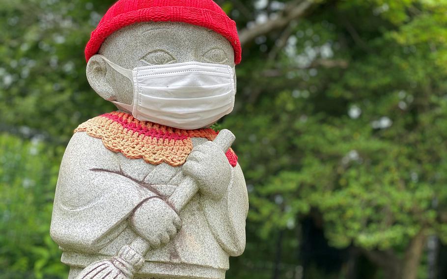 A mask-wearing statue sits atop Mount Takao, a popular hiking spot near Camp Zama and Yokota Air Base, Japan, Saturday, June 27, 2020.