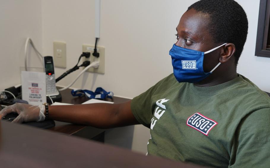 Petty Officer 2nd Class Gyapong Kusi mans the front desk inside the USO at Yokosuka Naval Base, Japan, Monday, June 29, 2020.