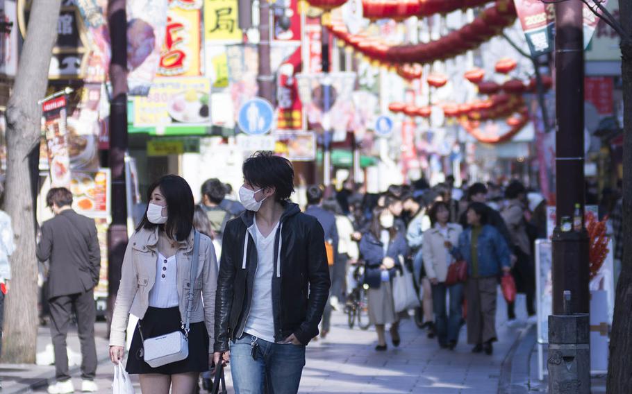 Tourists stroll through Chinatown in Yokohama, Japan, March 18, 2020.