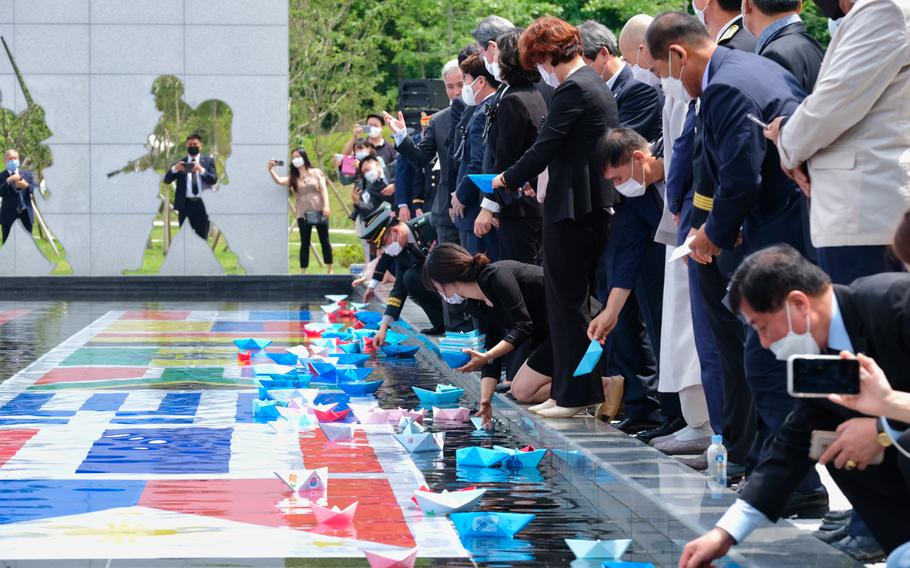 People release paper boats, made by children, into a pond as a proclamation of peace during a Korean War memorial service at Osan Jukmiryeong Peace Park in Osan, South Korea, Sunday, July 5, 2020.