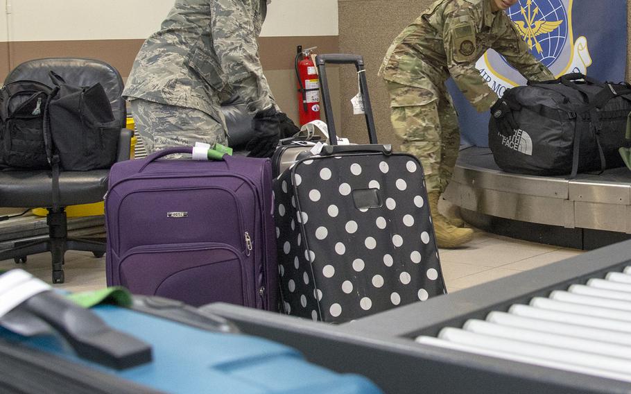 Airmen move baggage onto a conveyor belt ahead of a Patriot Express flight at Andersen Air Force Base, Guam, March 7, 2020.