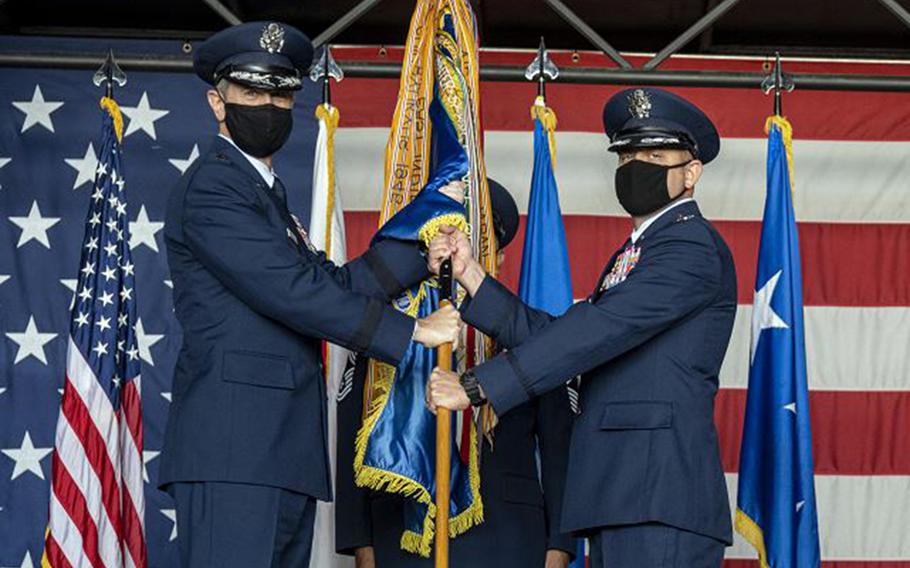 Lt. Gen. Kevin Schneider, commander of U.S. Forces Japan and 5th Air Force, left, passes a guidon to new 35th Fighter Wing commander Col. Jesse Friedel, during a ceremony at Misawa Air Base, Japan, Monday, July 13, 2020.
