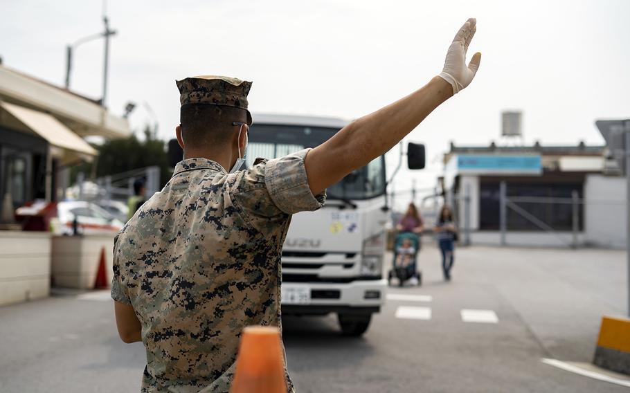 Marines conduct health and wellness checks for people entering Camp Foster, Okinawa, April 3, 2020.