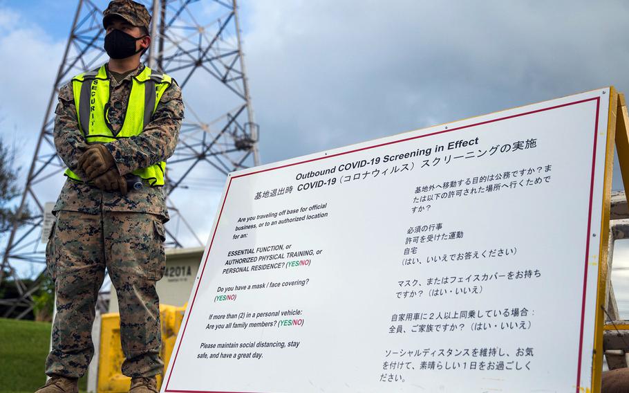 A Marine waits to conduct temperature checks and screen personnel at Camp Courtney, Okinawa, July 13, 2020.