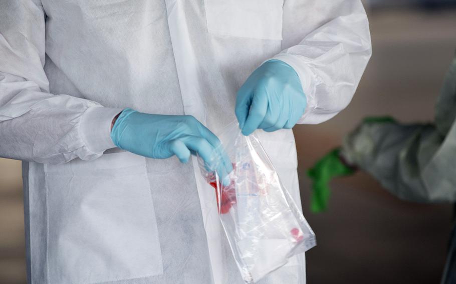 An airman with the 18th Medical Group seals a COVID-19 test sample at Kadena Air Base, Okinawa, March 20, 2020.