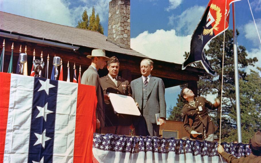 Gen. Leslie Groves, center, head of the Manhattan Project, presents the Army-Navy "E" Award flag to the Los Alamos laboratory with lab director J. Robert Oppenheimer, left, and University of California President Robert Sproul present on Oct. 16, 1945.