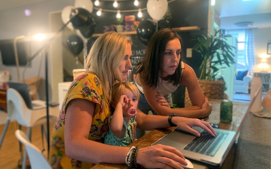 Amy Dobbins, left, and Sarah Murphy prepare for the virtual launch of their children's book, "Good Morning Yokosuka," on Tuesday, July 28, 2020. They are joined by Dobbins' 2-year-old daughter, Brinley.