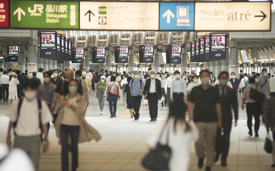 Commuters wear masks as they traverse Shinagawa Station in central Tokyo, July 13, 2020.