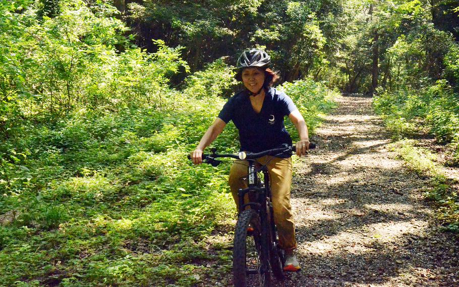 Tama Hills Recreation Center employee Yuki Ono takes an electric mountain bike for a spin on the center's trails in western Tokyo, Thursday, Aug. 6, 2020.