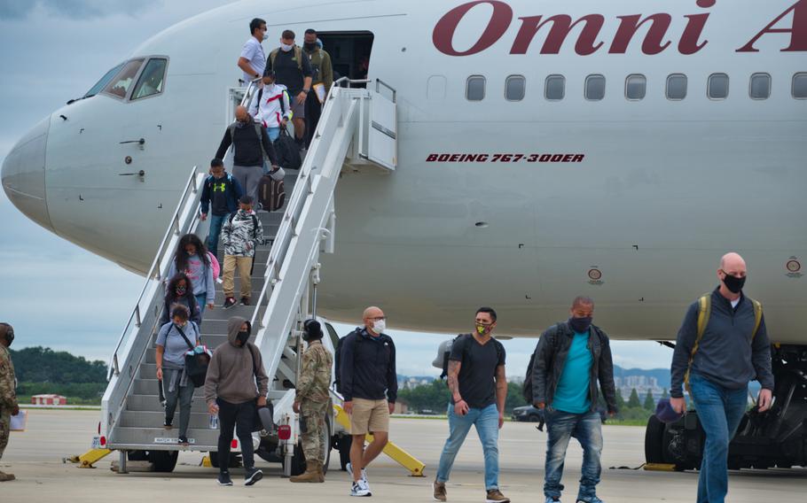 Service members and their families depart a Patriot Express flight from the United States at Osan Air Base, South Korea, July 14, 2020.