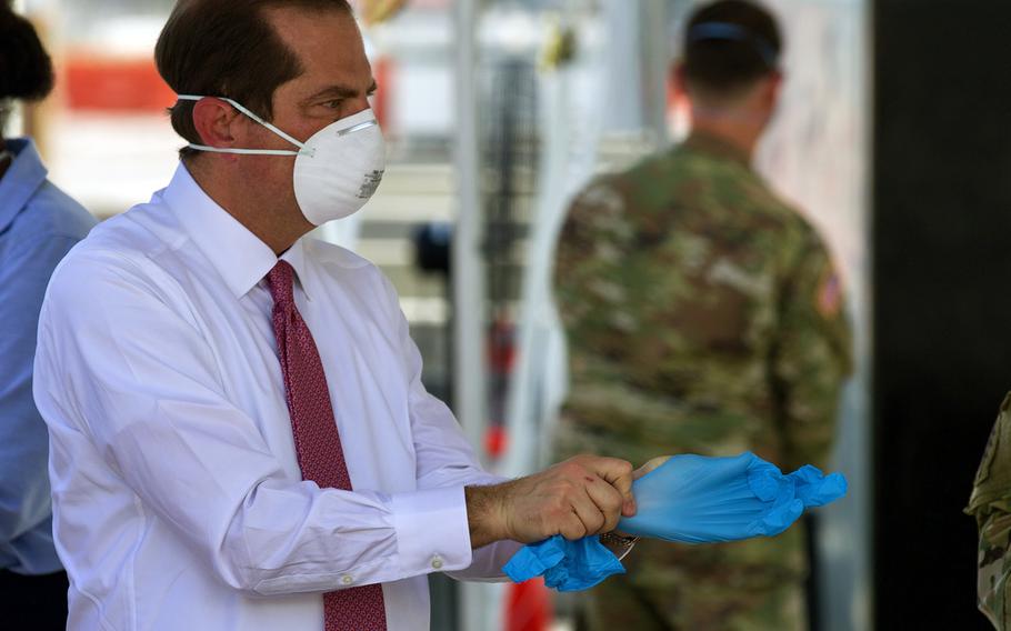 Secretary of Health and Human Services Alex Azar puts on protective equipment before joining the Florida National Guard for a tour of a coronavirus-testing site in Jacksonville, Fla., May 22, 2020.