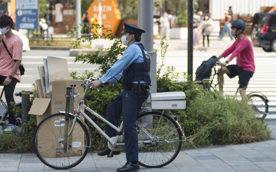 A police officer wears as mask while patrolling the popular Omotesando district in central Tokyo, Friday, Aug. 14, 2020. Akifumi Ishikawa/Stars and Stripes