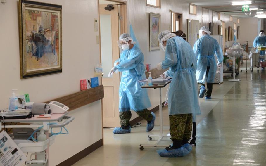 Members of a Japan Self-Defense Force medical team, one of many deployed to Okinawa at Gov. Denny Tamaki's request, care for coronavirus patients at an unidentified hospital somewhere in the prefecture, Aug. 19, 2020.