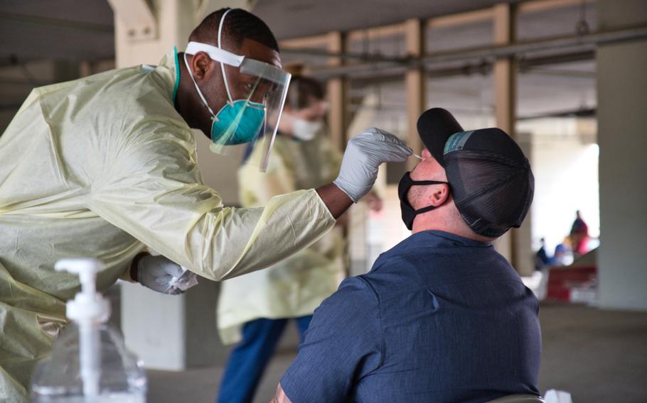 Staff Sgt. Lamaar Melvin of the 51st Medical Operations Squadron administers a coronavirus test at Osan Air Base, South Korea, July 14, 2020. 