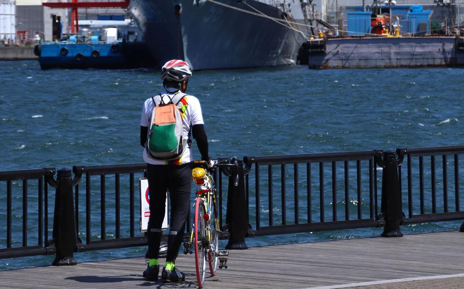 A cyclist takes a break outside Yokosuka Naval Base, Japan, April 14, 2020. 