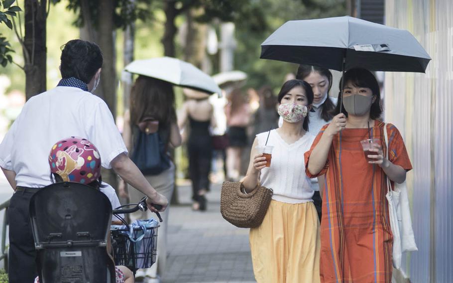 People wear masks to guard against the coroanvirus during a recent afternoon in the Omotesando distrcit of central Tokyo. 