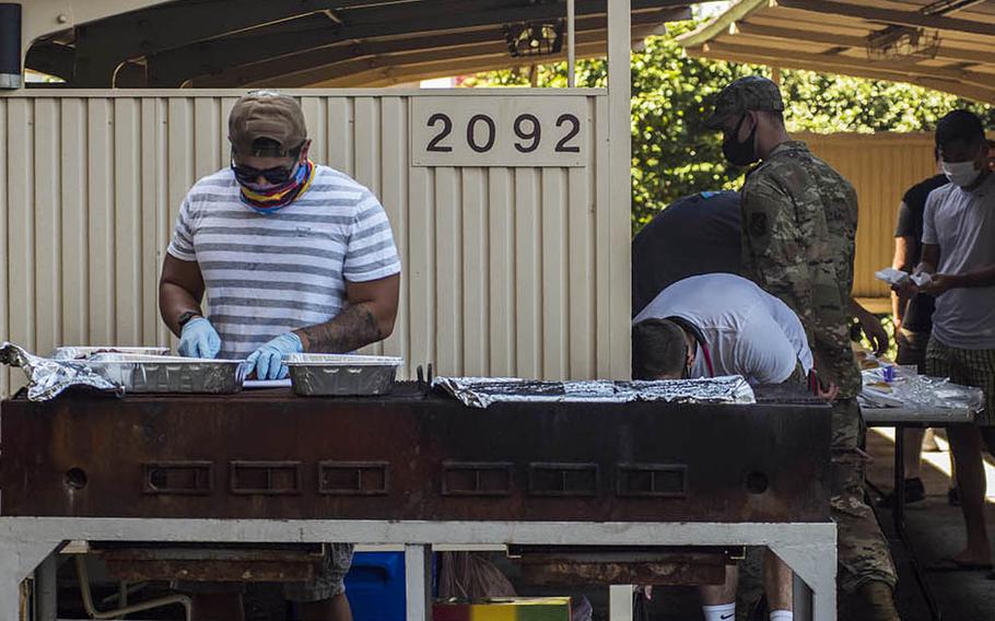 A volunteer prepares food during a special barbecue for single service members under quarantine at Yokota Air Base, Japan, Friday, Sept. 4, 2020. 