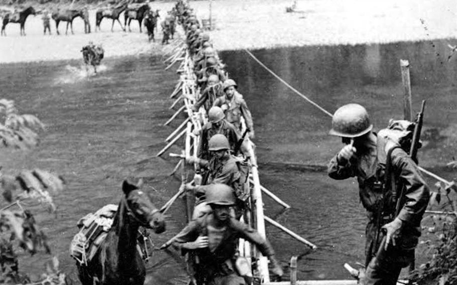 Members of Merrill's Marauders, gaunt from disease and malnutrition, cross a bridge over Tanai River, Burma, March 18, 1944.