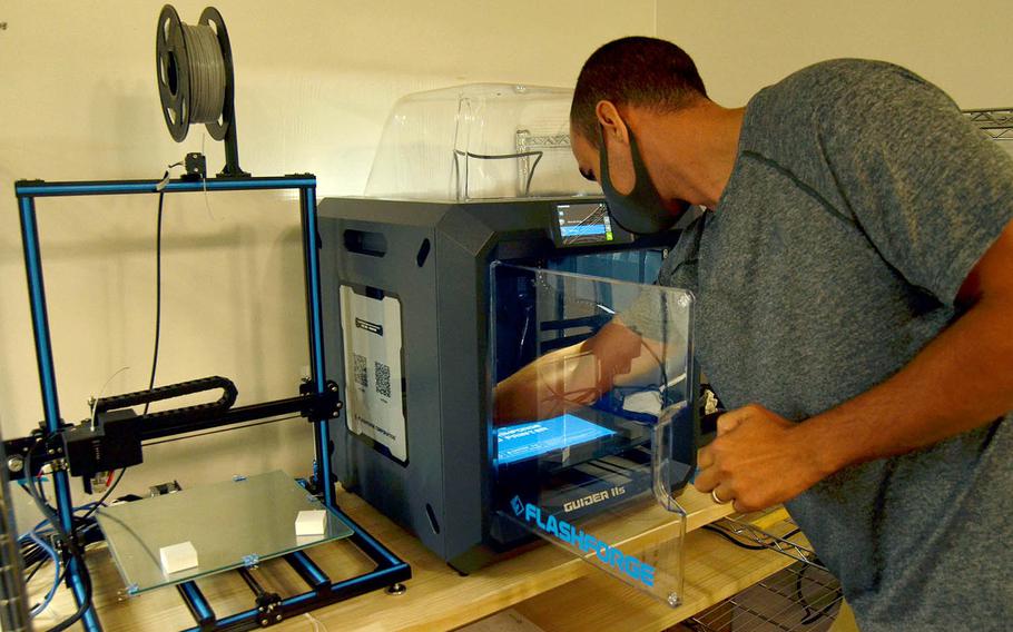 The chief technology officer for YokoWerx, Air Force Master Sgt. Ken Martin, demonstrates the innovation lab's 3D printer at Yokota Air Base, Japan, Sept. 25, 2020.