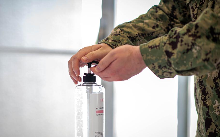 A sailor sanitizes his hands before entering the exchange at Yokosuka Naval Base, Japan, Aug. 13, 2020.