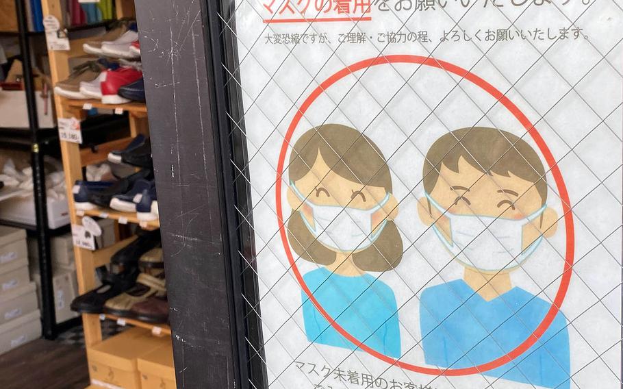 A sign outside a shop in Kamakura, Japan, reminds patrons to wear a mask, Saturday, Oct. 3, 2020.
