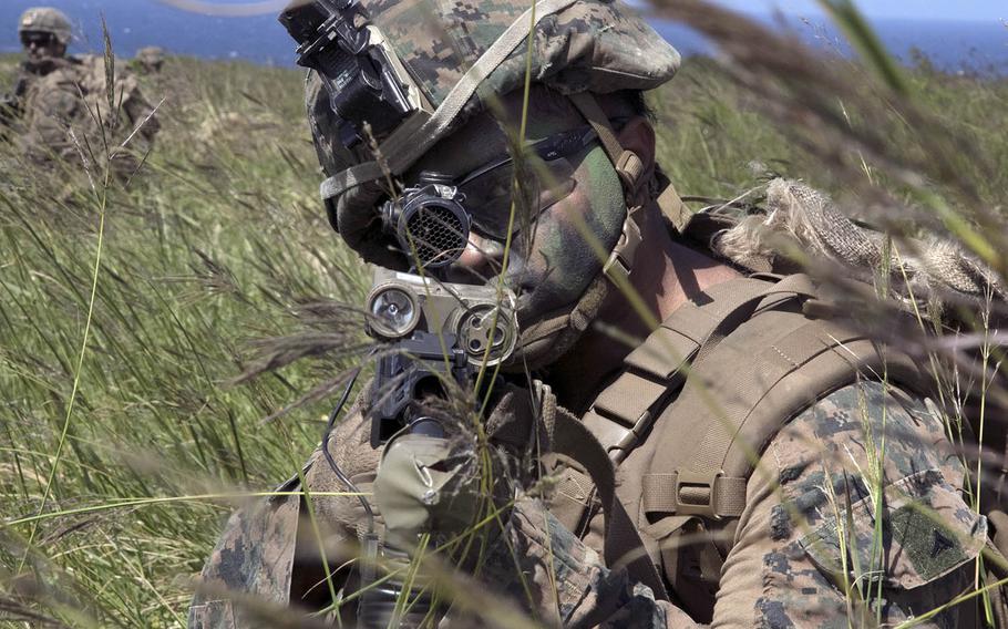 A Marine scans for enemy troops after taking over the airfield at Ie Shima, Okinawa, during Noble Fury drills Wednesday, Oct. 7, 2020.