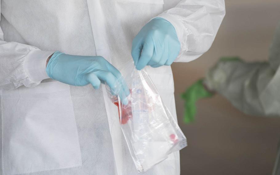 An airman with the 18th Medical Group seals a coronavirus test sample at Kadena Air Base, Okinawa, March 20, 2020.