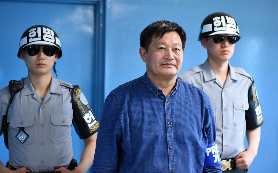 A man poses with South Korean soldiers on the North Korean side of the Joint Security Area during a tour on May 24, 2017.