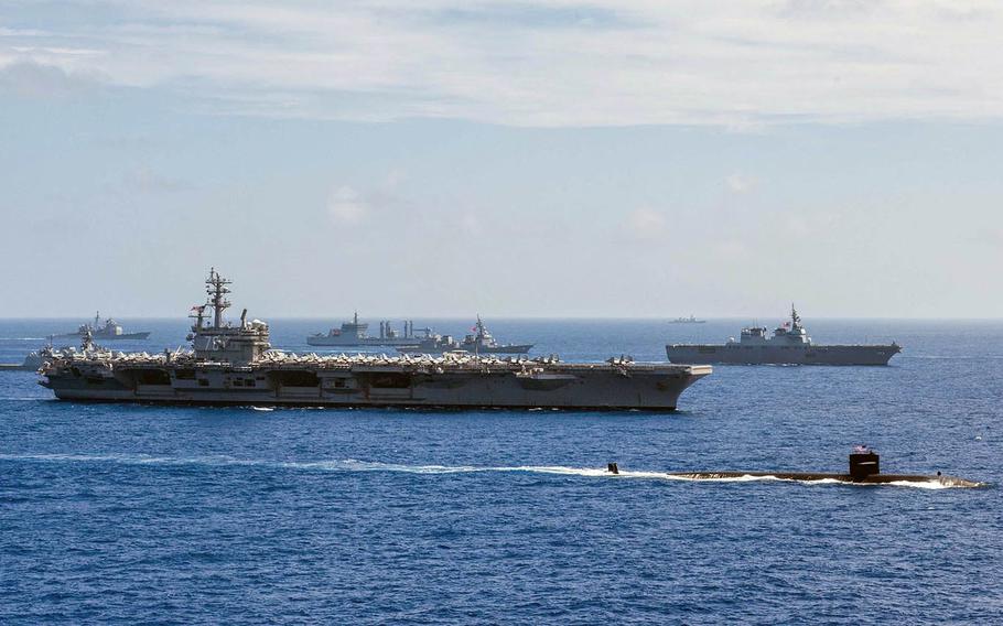 Ships from the U.S. and Indian navies and Japan Maritime Self-Defense Force sail in formation during the annual Malabar exercise in 2018.