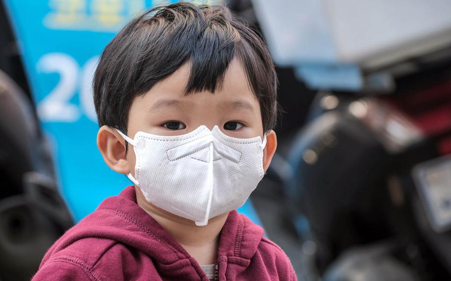 A child wears his mask while browsing local shops with his mother outside Osan Air Base, South Korea, Oct. 20, 2020.
