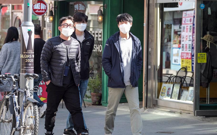 Pedestrians wear masks to guard against the spread of the coronavirus outside Osan Air Base, South Korea, Oct. 20, 2020.