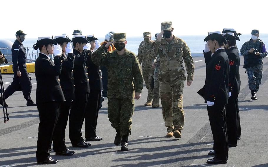 U.S. Forces Japan chief Lt. Gen. Kevin Schneider, right center, and Japan's top military leader, Gen. Koji Yamazaki, are welcomed aboard the helicopter destroyer JS Kaga on Monday, Oct. 26, 2020. Seth 