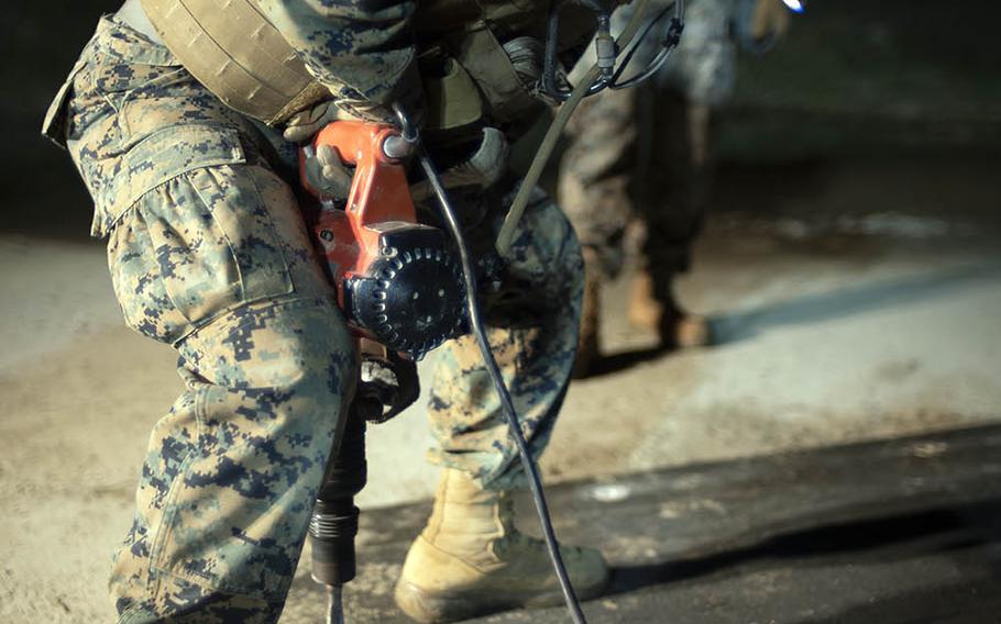 A combat engineer with Marine Wing Support Squadron 171 repairs airfield damage after a simulated missle strike during the Active Shield exercise at Marine Corps Air Station Iwakuni, Japan, Oct. 29, 2020.