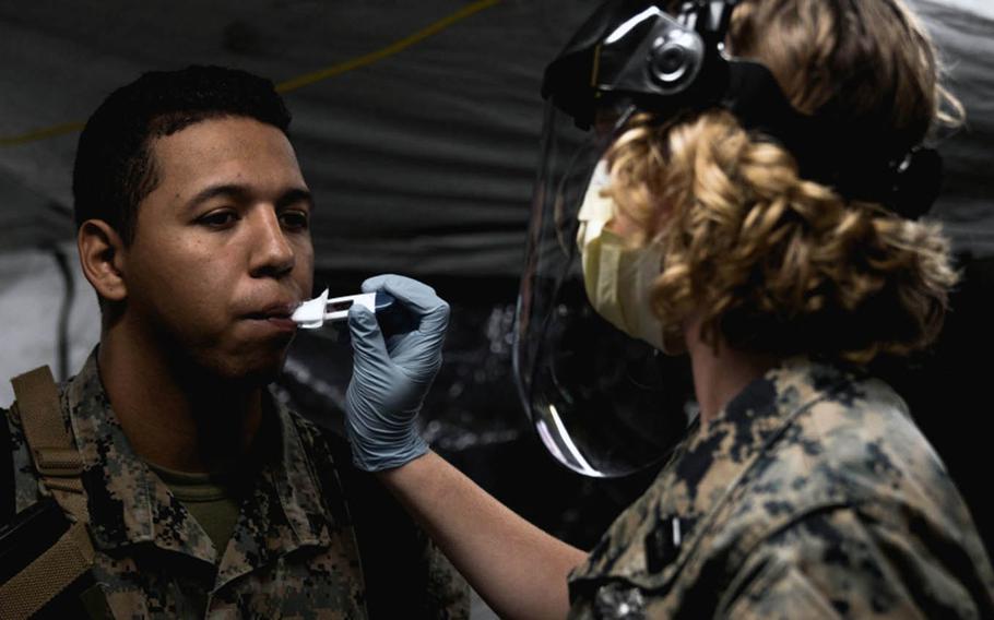 Marines and sailors are screened for the coronavirus at  Marine Corps Air Station Cherry Point, N.C., after returning from an exercise overseas on March 24, 2020.