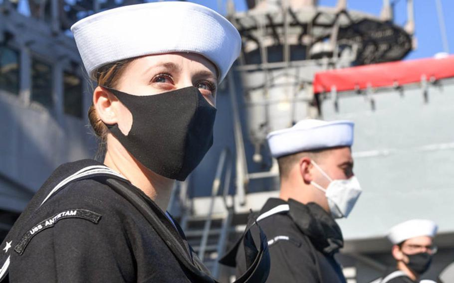 Petty Officer 1st Class Brittany Britos and other sailors man the rails as the guided-missile cruiser USS Antietam returns to Yokosuka Naval Base, Japan, after a nine-month deployment, Tuesday, Nov. 10, 2020.