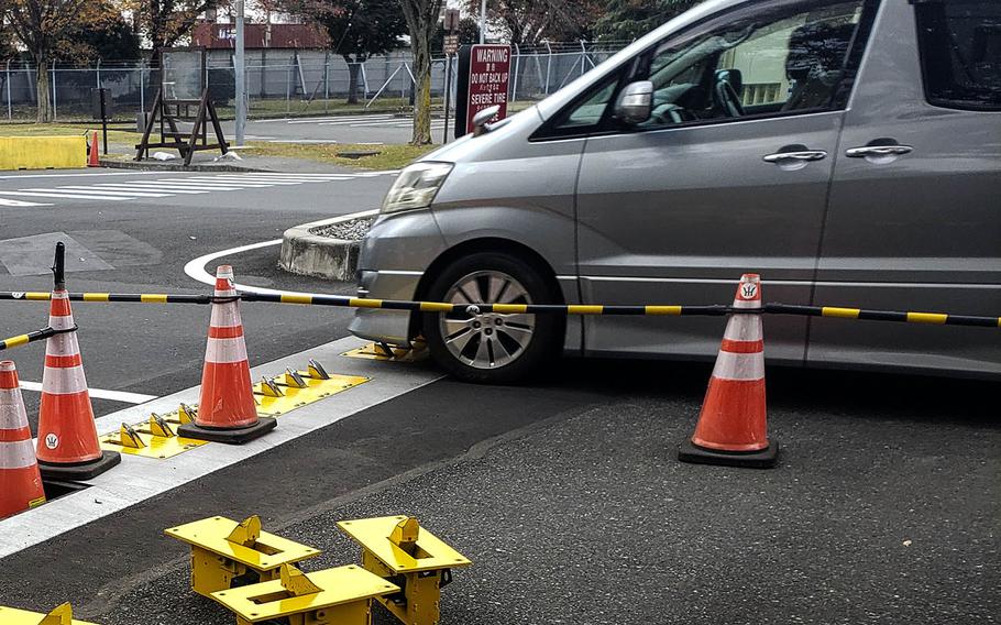 A van departs Yokota Air Base in western Tokyo while a recently installed tire shredder system that has received complaints undergoes maintenance, Thursday, Nov. 12, 2020.